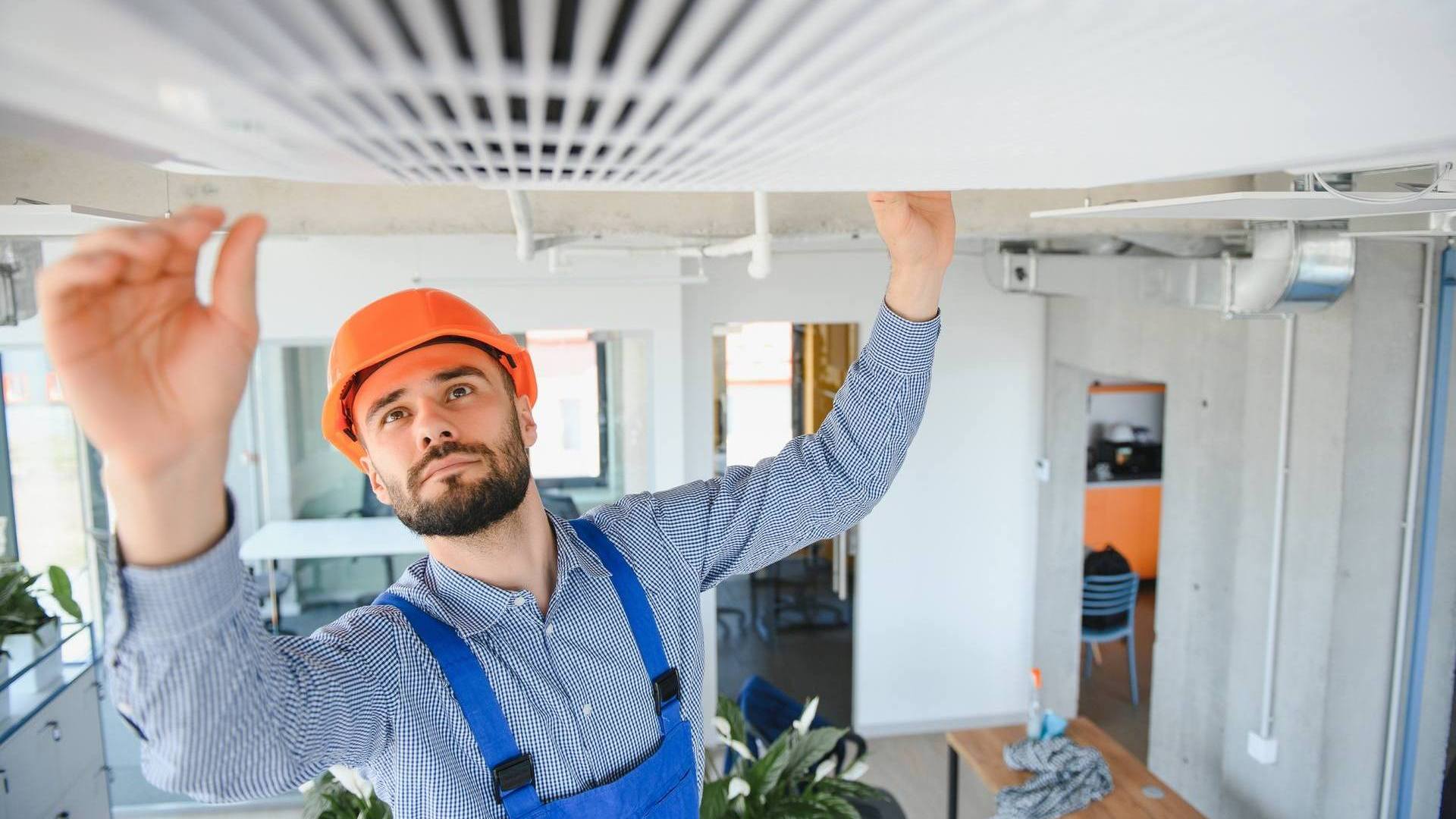 Electrician repairing air conditioner indoors